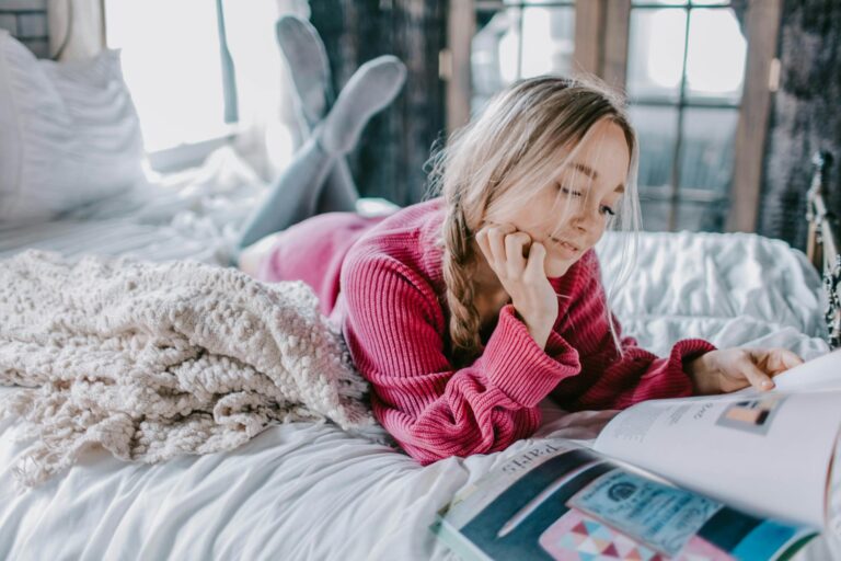 woman reading book on bed